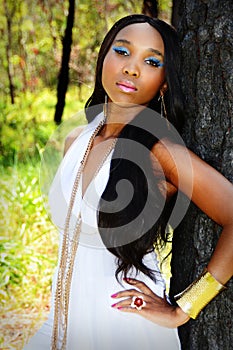 Young Beautiful African Woman Leaning Against a Tree