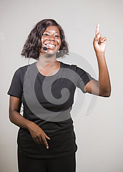 Young beautiful afro American woman coaching at seminar - happy and successful black businesswoman with headset speaking giving