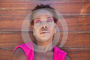 Young and beautiful Afro American woman doing different postures and expressions on a wooden background. The woman is smiling, sad