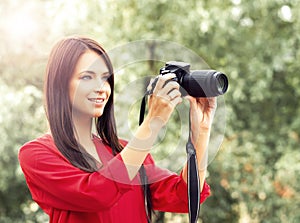 Young beautiful amateur female photographer with new dslr camera