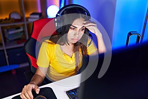 Young beautiful arab woman streamer stressed using computer at gaming room