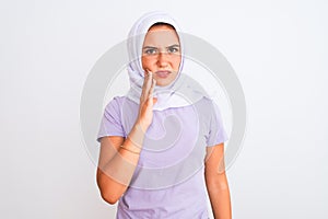 Young beautiful arabian girl wearing hijab standing over isolated white background touching mouth with hand with painful
