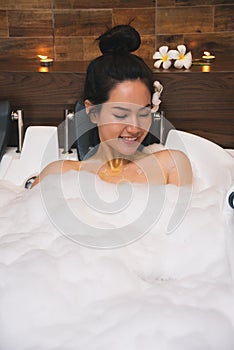 Young beautiful asia woman takes bubble bath