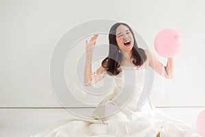 Young beautiful asian bride women in white dress feeling Happy and funny with balloon