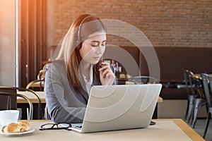 Young beautiful asian businesswoman with headset in cafe.
