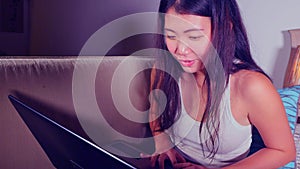 Young beautiful Asian Chinese student girl happy and relaxed at home sofa couch using internet on laptop computer networking cheer