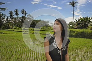Young beautiful Asian Chinese tourist exploring jungle and rice field pad area in Bali Indonesia relaxed and happy enjoying holida
