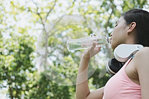 young beautiful asian fitness athlete woman drinking water after