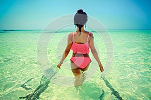 Young beautiful asian girl in bikini enjoy summer holidays on tropical paradise beach. Summer vacation and LifeStyle concept.