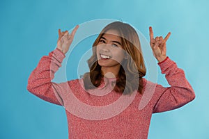 Young beautiful asian girl posing rock n roll in studio