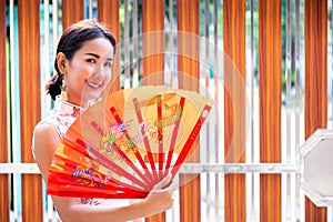 Young Beautiful Asian Girl with Qipao, Happy and Smiley Friendly in Chinese New Year Festival in Thailand.