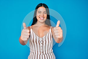 Young beautiful asian girl wearing casual clothes approving doing positive gesture with hand, thumbs up smiling and happy for