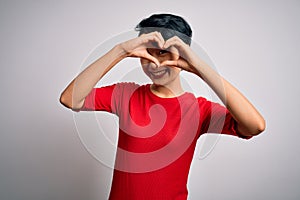 Young beautiful asian girl wearing casual red t-shirt standing over isolated white background Doing heart shape with hand and