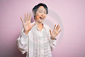 Young beautiful asian girl wearing casual shirt standing over isolated pink background afraid and terrified with fear expression