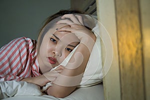 Young beautiful Asian Korean girl lying on bed late night awake looking thoughtful suffering insomnia sleeping disorder feeling