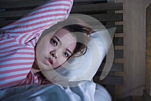 Young beautiful Asian Korean girl lying on bed late night awake looking thoughtful suffering insomnia sleeping disorder feeling