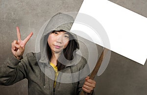 Young beautiful Asian Korean student woman as protestor and pacifist holding protest billboard with blank copy space standing