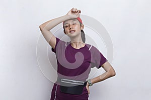 Young beautiful asian sport woman feeling tired after workout on white background