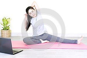 Young beautiful asian woman doing training fitness workout sport exercise feel no stress free, using laptop while sitting on floor