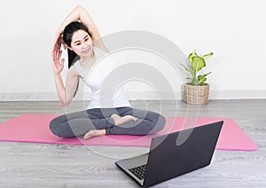 Young beautiful asian woman doing training fitness workout sport exercise feel no stress free, using laptop while sitting on floor