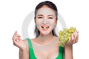 Young beautiful asian woman eating fresh grapes isolated on whit