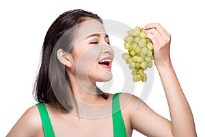 Young beautiful asian woman eating fresh grapes isolated on whit