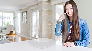 Young beautiful asian woman with long hair wearing denim jacket Pointing with hand finger to face and nose, smiling cheerful