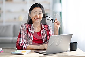 Young Beautiful Asian Woman Posing At Desk With Laptop In Home Office