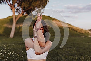 Young beautiful asian woman practicing yoga mindfullness at sunset outdoors. Sports and healthy Lifestyle