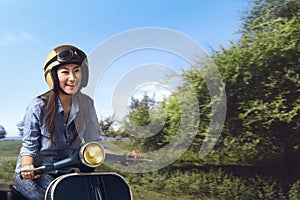 Young beautiful asian woman riding his scooter