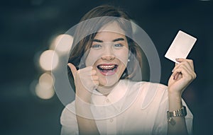 Young beautiful asian woman smiling and holding blank card