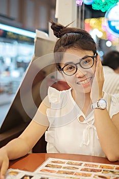 Young beautiful asian woman smiling when looking menu dinner time in restaurant or coffee shop