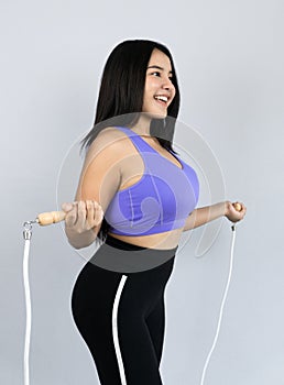 Young and beautiful Asian woman in sportswear skipping