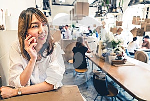 Young and beautiful Asian woman talking on mobile phone at coffee shop, communication or cafe casual lifestyle concept