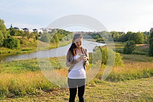 Young beautiful Asian woman using phone against relaxing view of nature