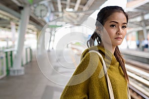 Young beautiful Asian woman waiting train at platform