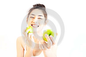 Young beautiful asian woman wearing a white tank top Exercise with pink yoga ball, orange juice and drinking water holding blue