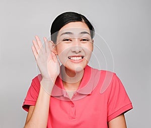 Young beautiful asian woman wore pink t shirt, Showed Listen  expression , on gray background photo