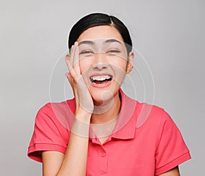 Young beautiful asian woman wore pink t shirt, Showed shy expression ,awestruck on gray background