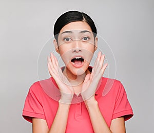 Young beautiful asian woman wore pink t shirt, Showed surprised  expression , on gray background