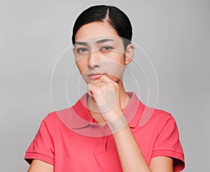 Young beautiful asian woman wore pink t shirt, Showed Thinking and serious expression , on gray background