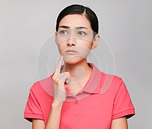 Young beautiful asian woman wore pink t shirt, Showed Thinking and serious expression , on gray background