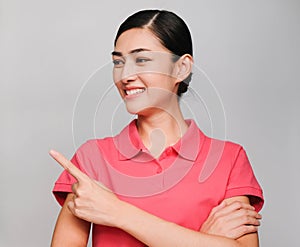 Young beautiful asian woman wore pink t shirt,smile and Pointing with confidence Showed smart expression , on gray background