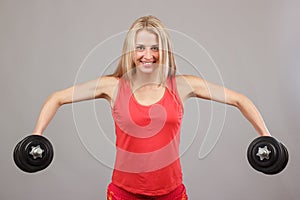 Young beautiful athletic girl holding dumbbells