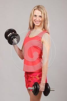 Young beautiful athletic girl holding dumbbells