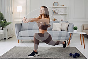 Young beautiful athletic girl in leggings and top makes lunges. Healthy lifestyle. Woman doing exercises at home.
