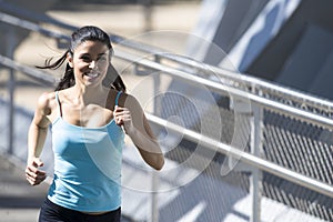 Young beautiful athletic sport woman running and jogging crossing modern metal city bridge