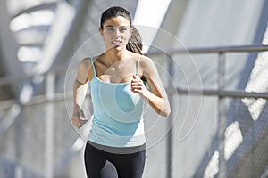 Young beautiful athletic sport woman running and jogging crossing modern metal city bridge