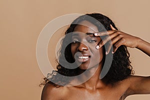 Young beautiful attractive african naked smiling woman touching her face