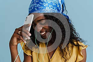 Young beautiful attractive long-haired curly smiling african woman with phone